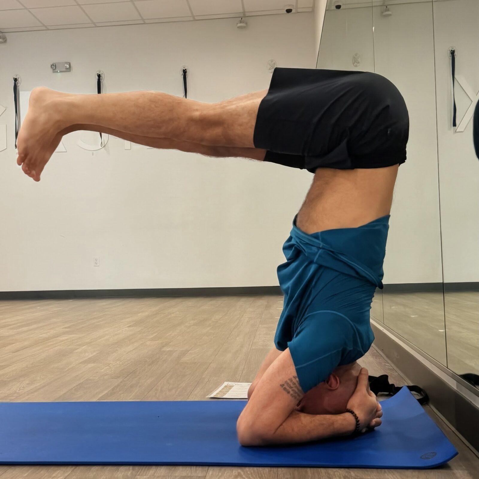 Raj in supported headstand with legs extended parallel to the floor