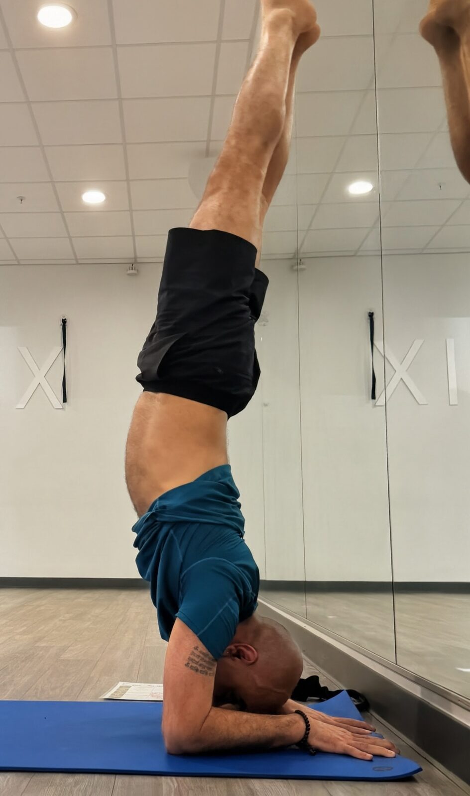 Raj in supported headstand beside the wall
