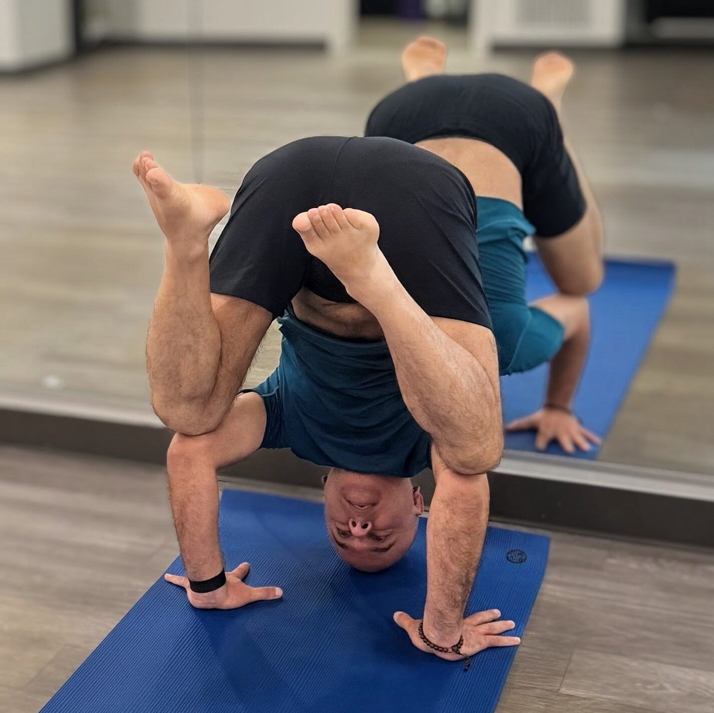 Raj entering tripod headstand with knees bent